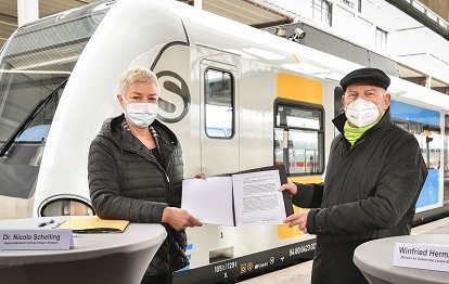 Regionaldirektorin Dr. Nicola Schelling und der Minister für Verkehr des Landes Baden-Württemberg Winfried Hermann bei der Unterzeichnung des Nachtrags zur Vereinbarung über die Ausstattung der Region Stuttgart mit Regionalisierungsmitteln vor der Kulisse der ersten neu designten S-Bahn (Bild: Ferdinando Iannone)