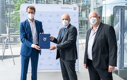 NRW-Verkehrsminister Hendrik Wüst (l.) übergibt den Förderbescheid an HCR-Geschäftsführer Karsten Krüger. Im Bild rechts MDL Thomas Nückel (Bild: Ministerium für Verkehr des Landes Nordrhein-Westfalen)