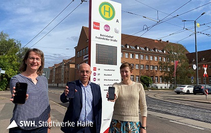 Kathrin Jähnert (links) und Andreas Völker (mittig) von der HAVAG testen zusammen mit Paula Ruoff (rechts) von FAIRTIQ den neuen Luftlinien-Tarif in der FAIRTIQ-App (Bild: HAVAG)